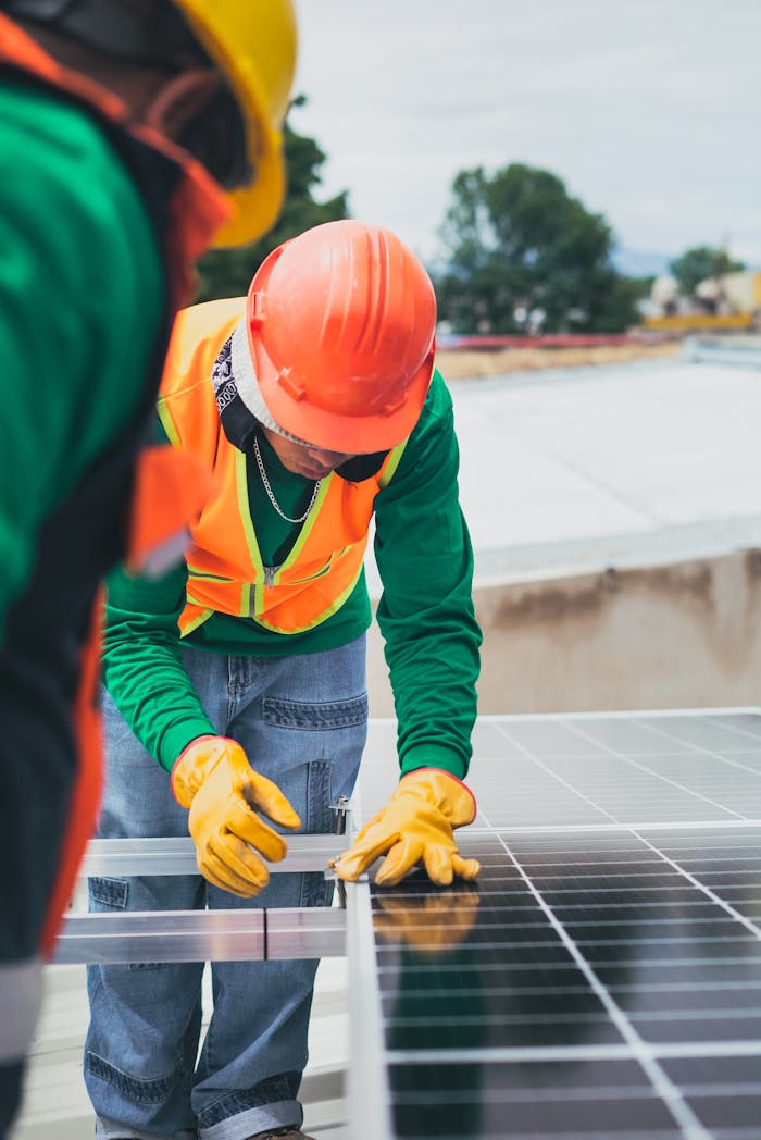 impact-img Worker in safety gear installing solar panels on a rooftop.