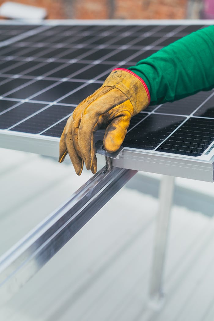hero-homepage Close-up of a worker's hand in protective glove installing a solar panel.